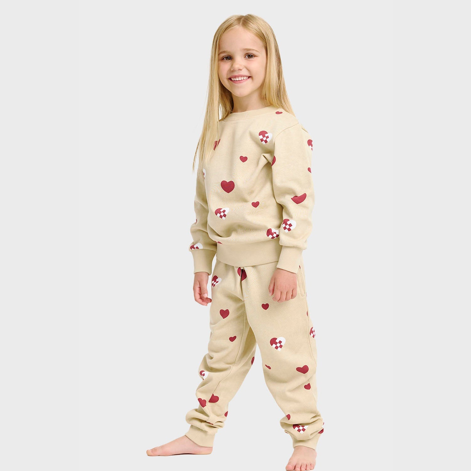 Beiges Kinder-Weihnachtspyjama mit Herzen und Lebkuchenmännchen aus Bio-Baumwolle.