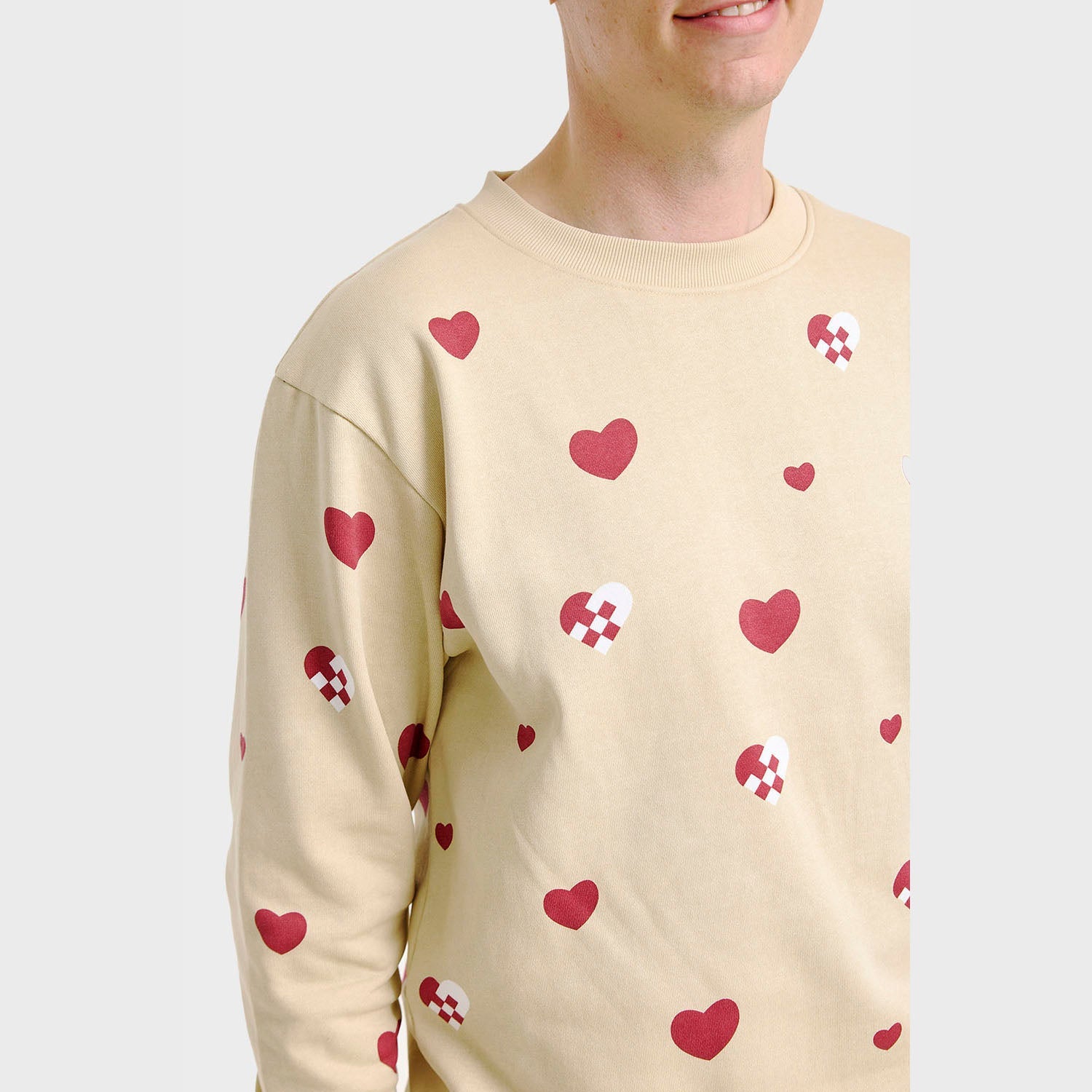 Beiger Weihnachtspyjama Herren-Sweatshirt mit roten Herzen und Zuckerstangenmuster.