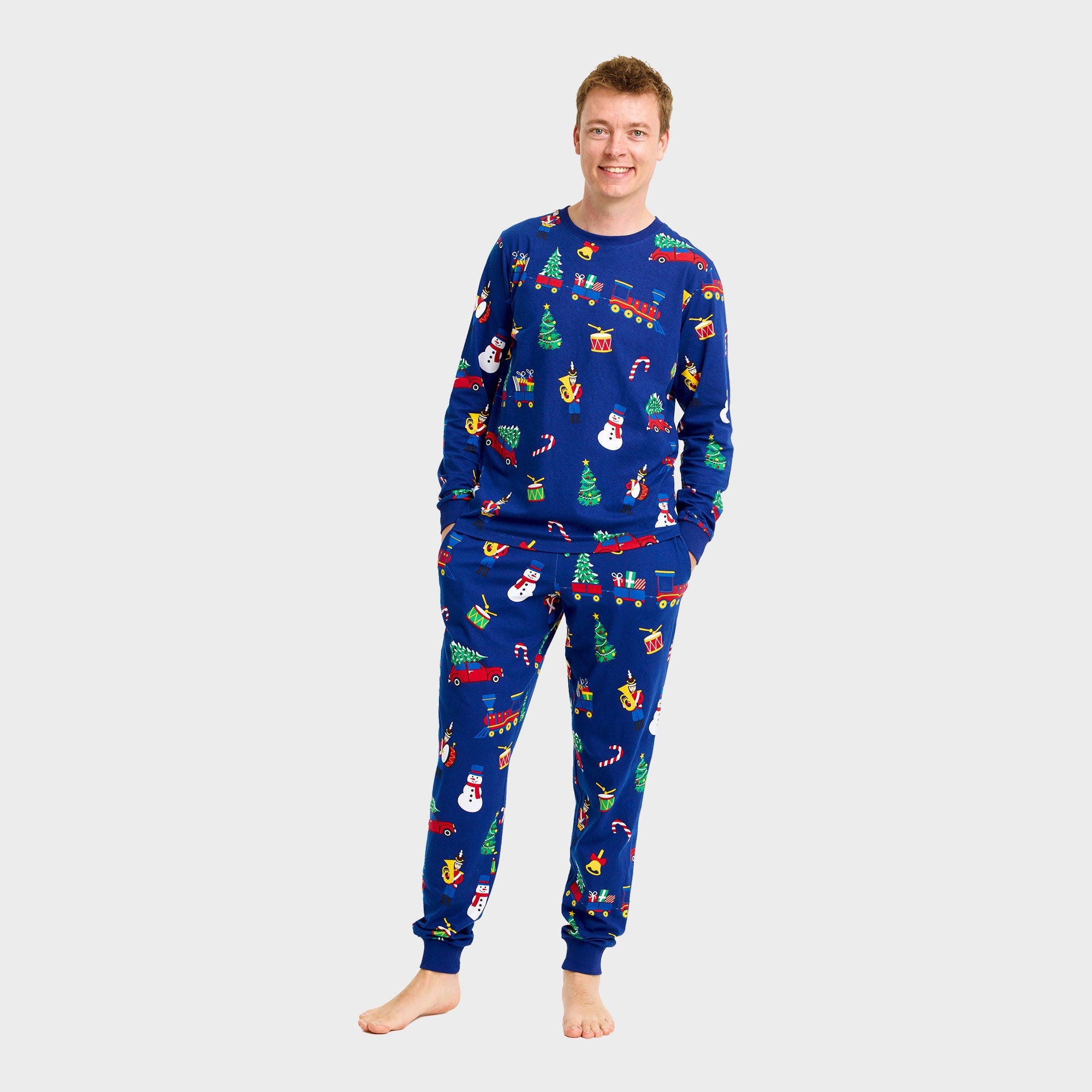 Weihnachtspyjama Herren aus blauem Baumwollstoff mit bunten Weihnachtsmotiven wie Schneemännern und Tannenbäumen.