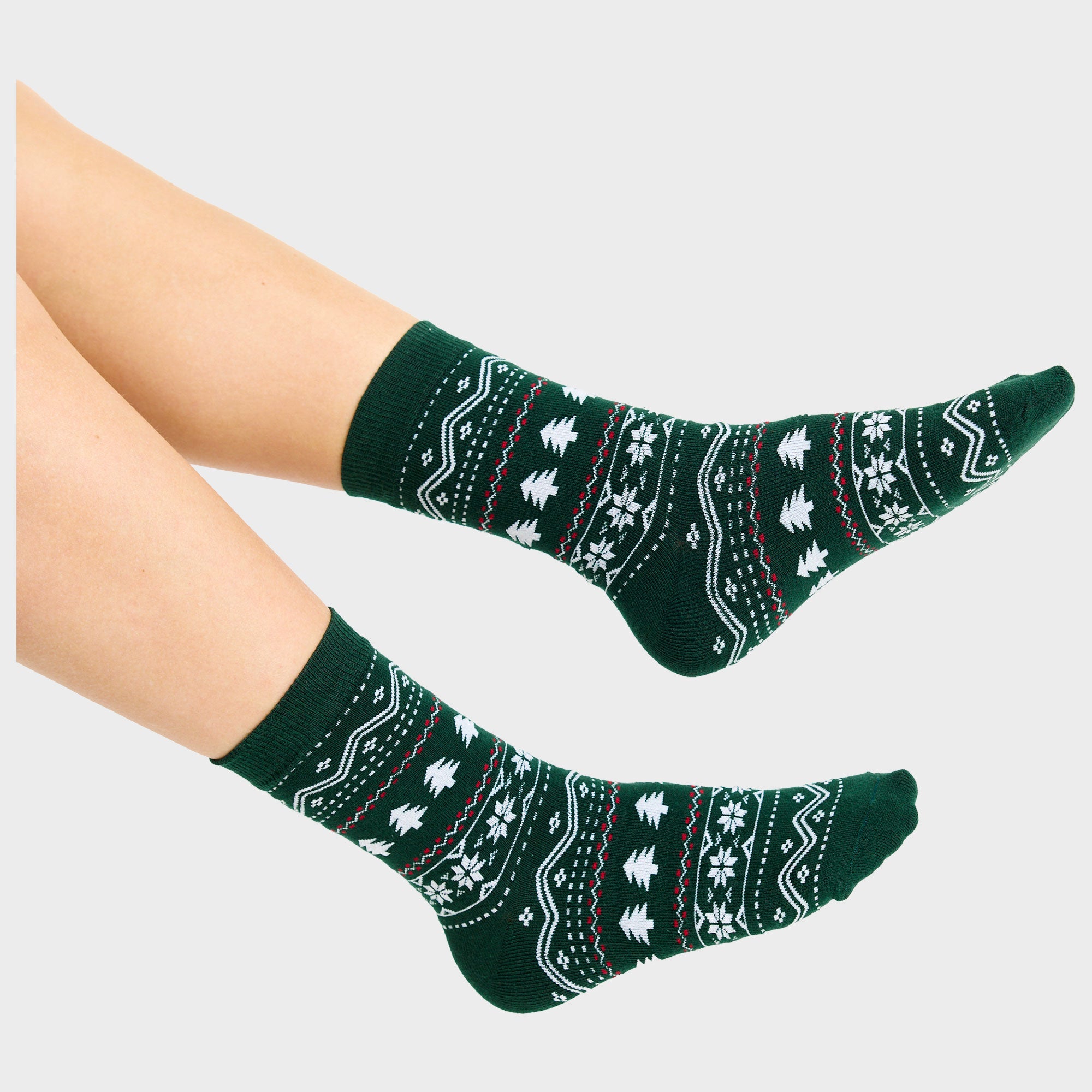 Ein Paar Füße mit grünen Weihnachtssocken.