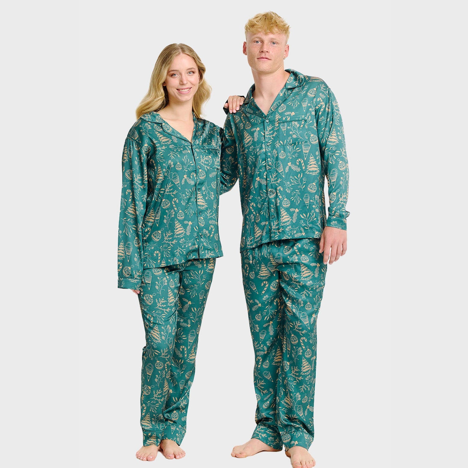 Grüne Satin-Weihnachtspyjama für Damen und Herren mit festlichem Muster, langärmlig und langbeinig.