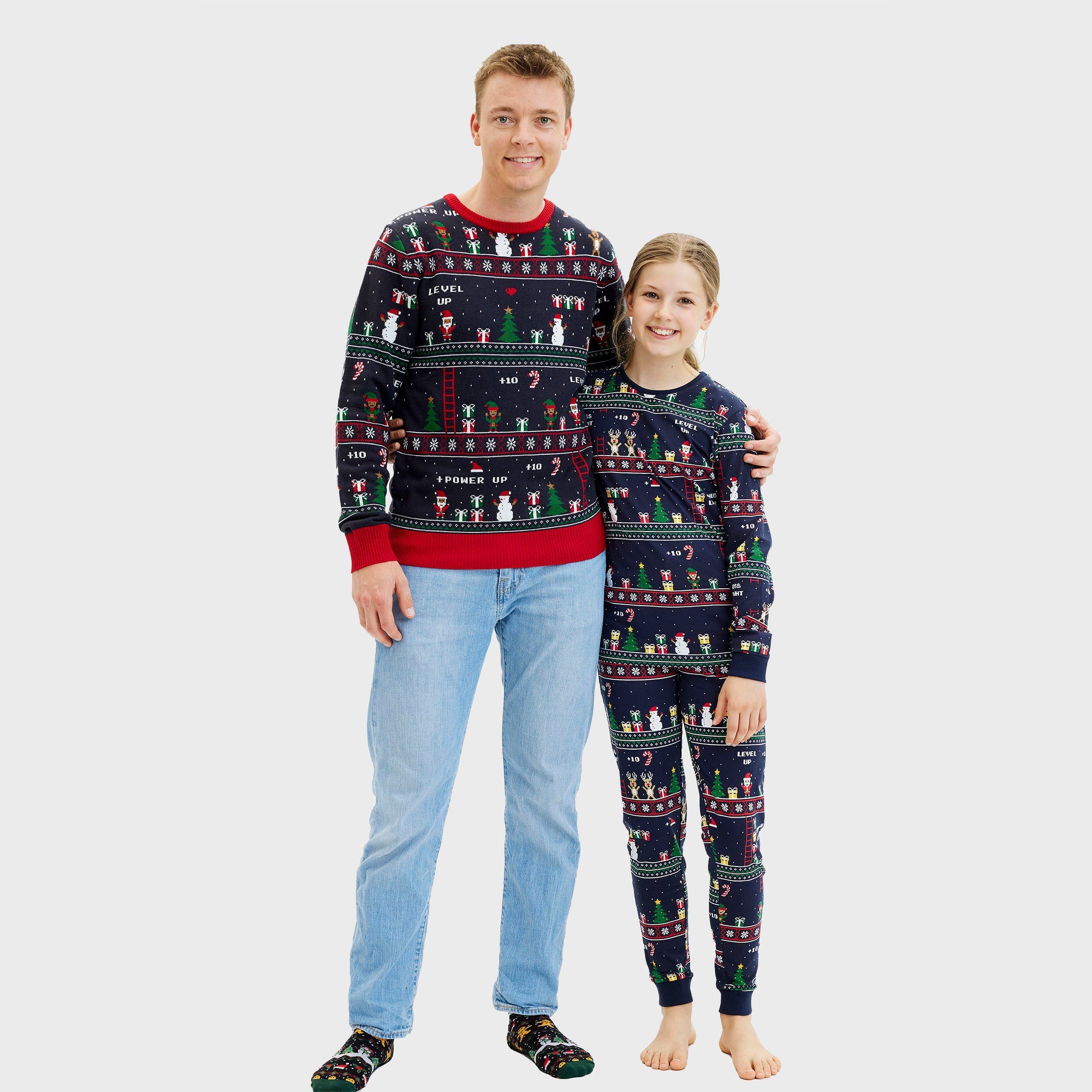 Dunkelblauer Weihnachtspullover Herren mit roten Bündchen und passender Weihnachtspyjama Damen im Retro-Gamer-Design.