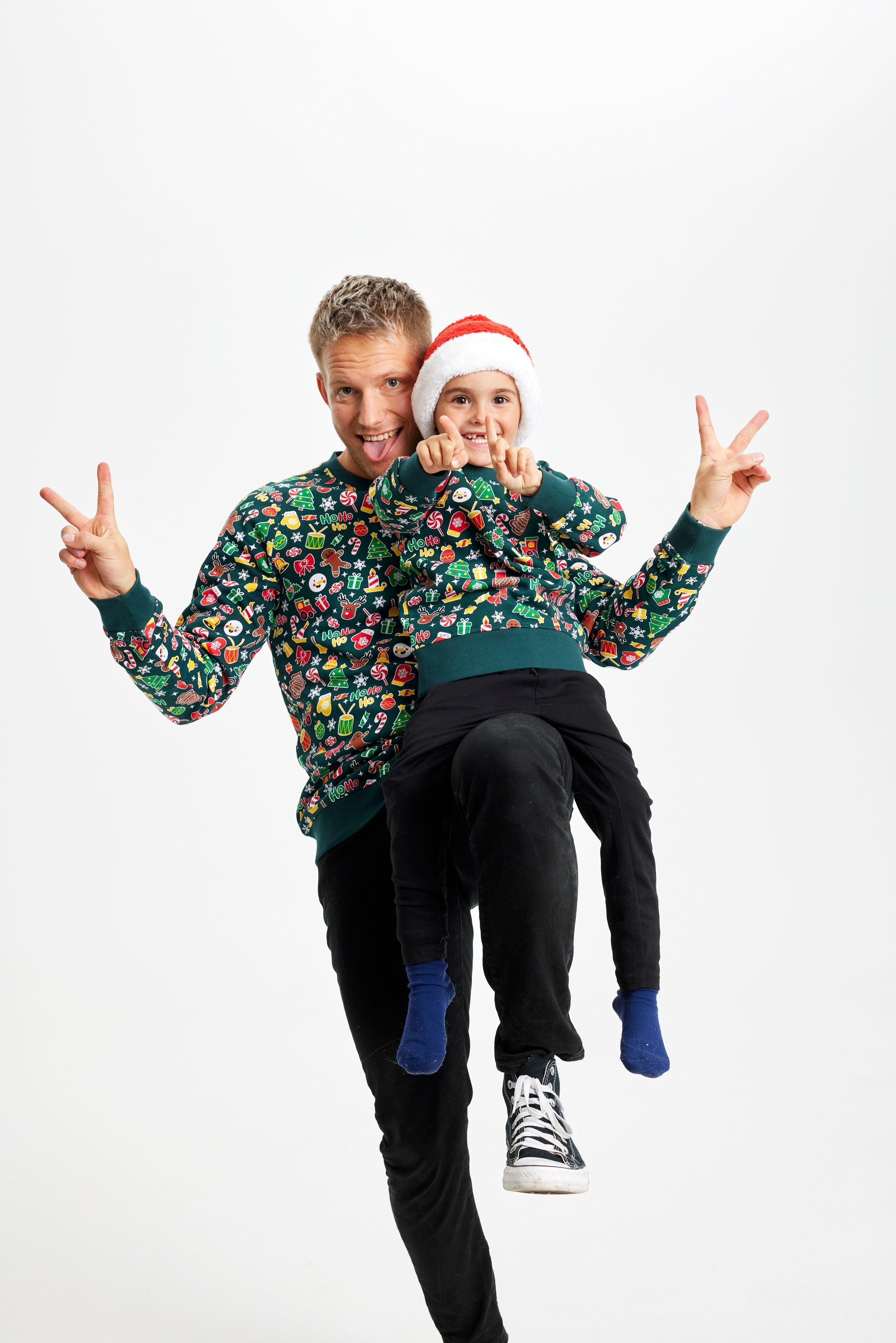 Eine lächelnde Frau, die einen grünen Weihnachtspulli mit Weihnachtsmuster trägt.