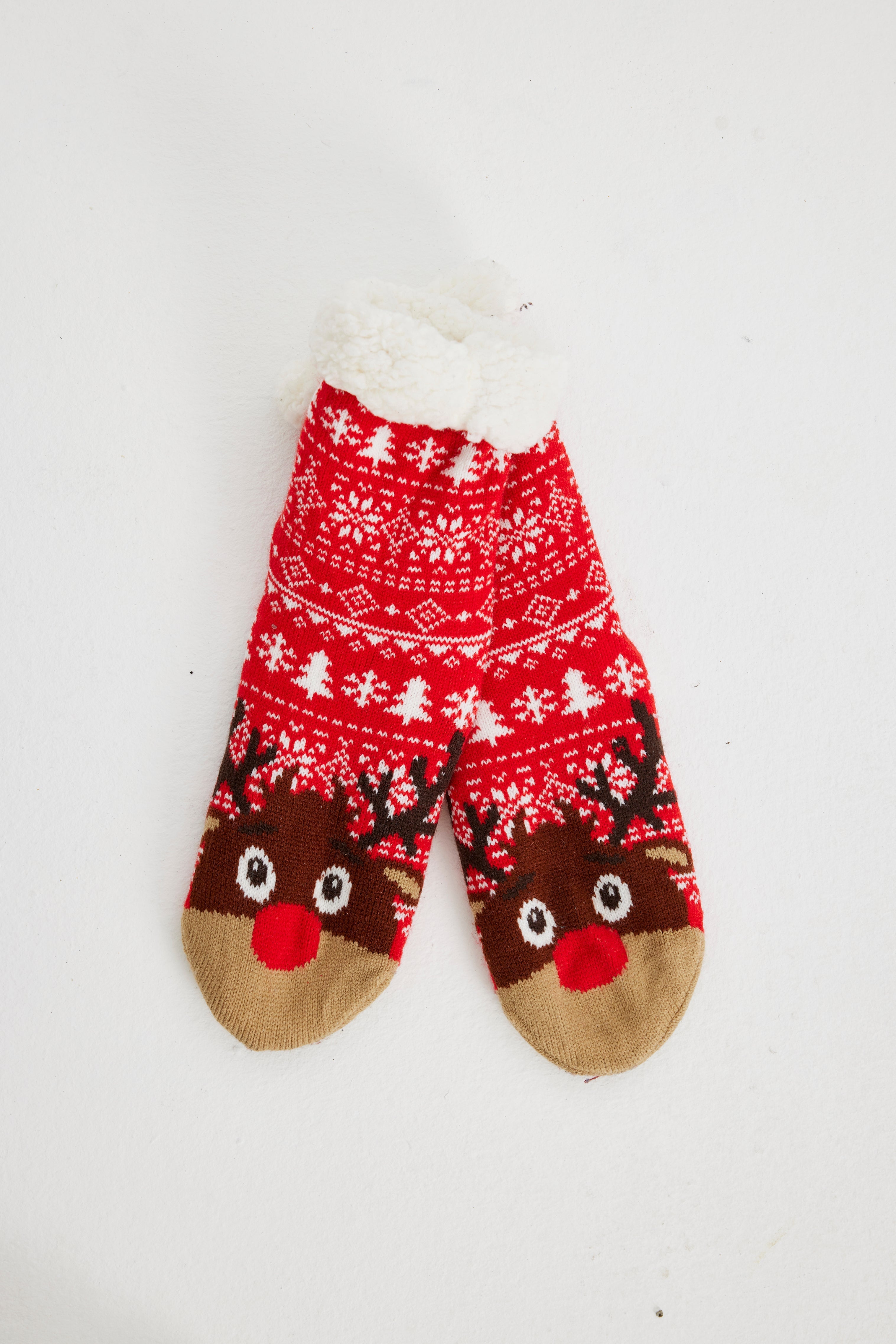 Ein Paar rote Weihnachtssocken mit einem Rentier darauf.