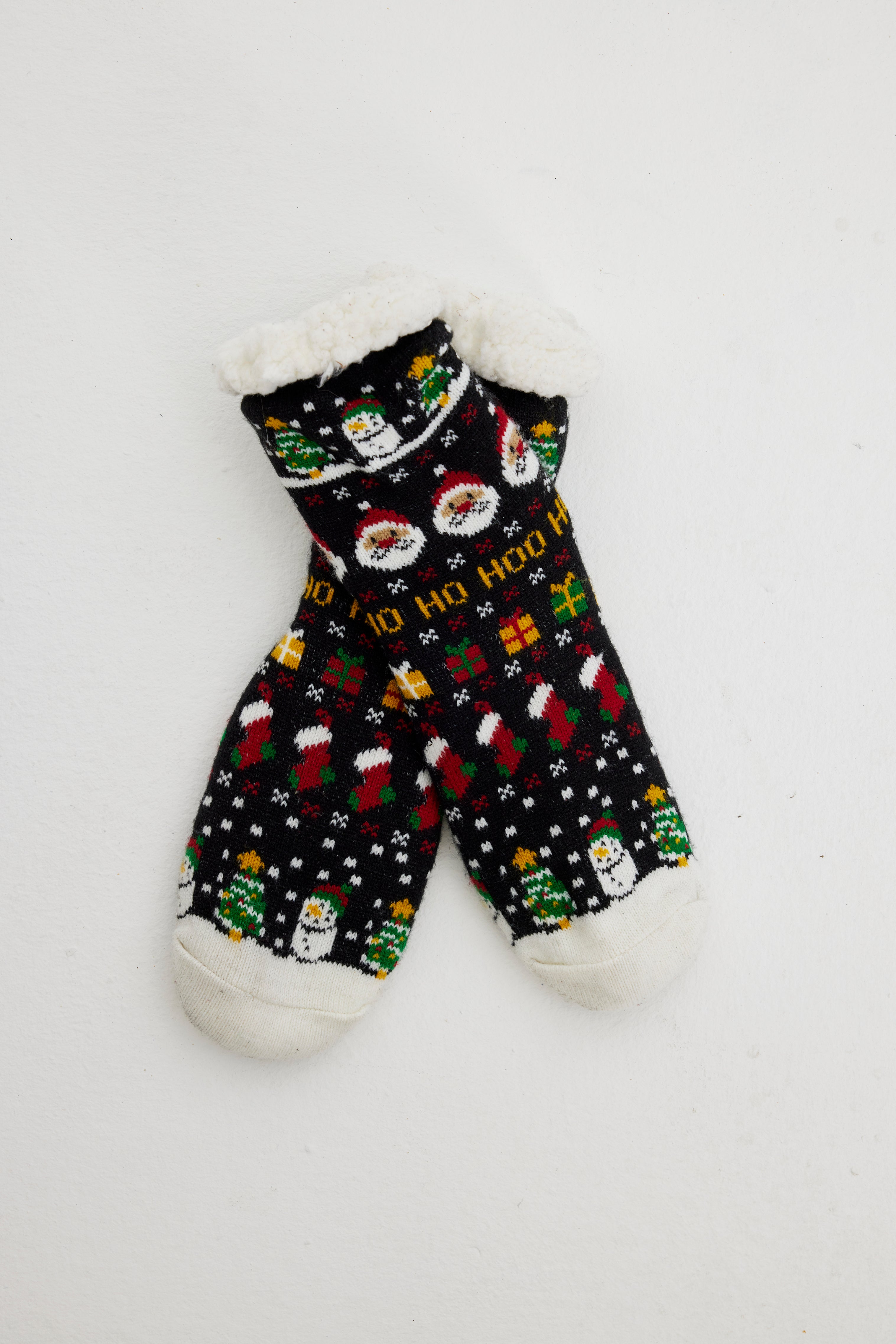 Ein Paar schwarze Weihnachtssocken mit einem Weihnachtsmuster darauf.