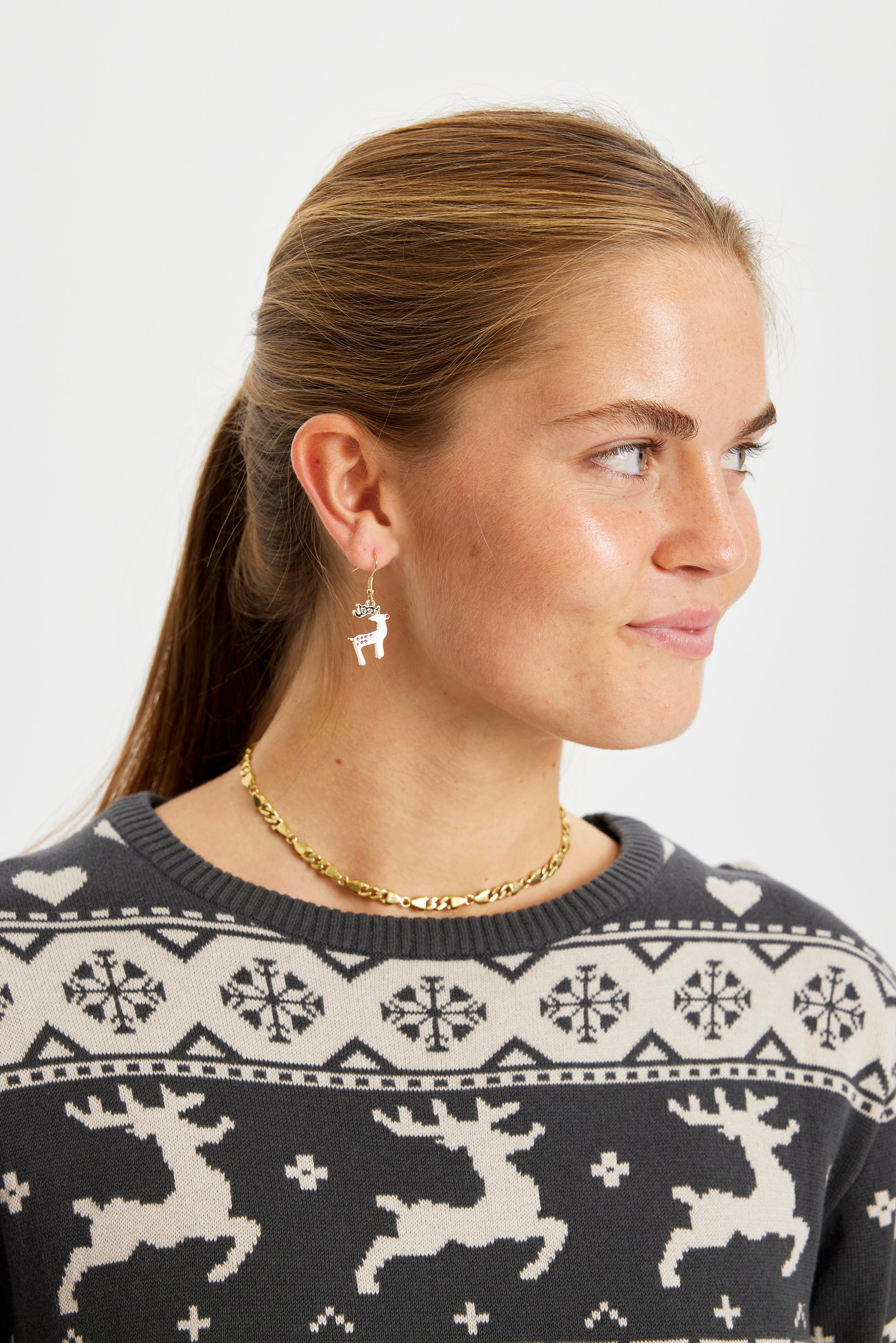 Eine Frau trägt Weihnachtsohrringe.