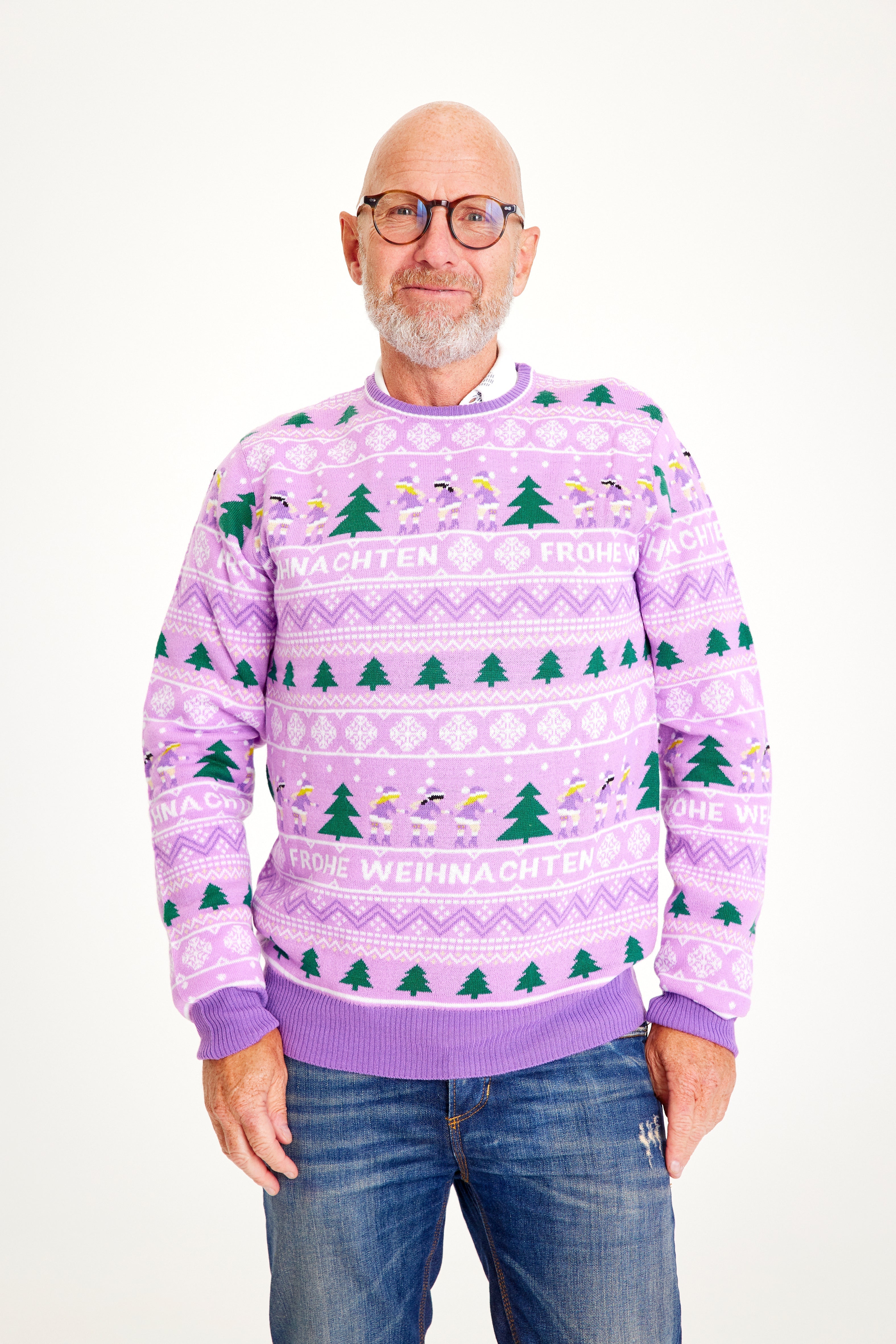 Ein Paar, das einen lila Weihnachtspulli mit Weihnachtsbäumen darauf trägt.